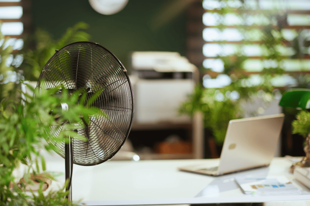 Ein Homeofficearbeitsplatz mit einem Ventilator zur Verbesserung der Luftqualität.