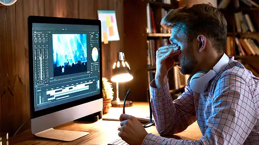 Mann vor Computer im Homeoffice mit Augenbelastung – Herausforderung der Telearbeit am Bildschirmarbeitsplatz